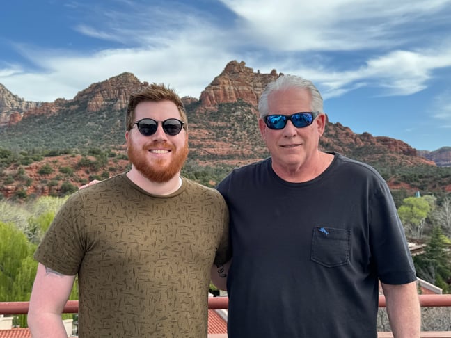 two men smiling for a photo in Sedona, Arizona, against the red rock backdrop